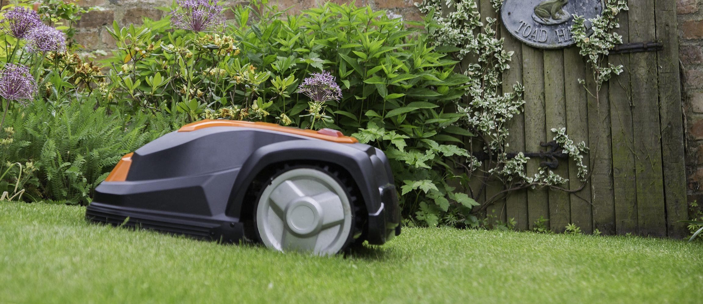 Robotgräsklippare av modell YardForce som klipper gräset i trädgård