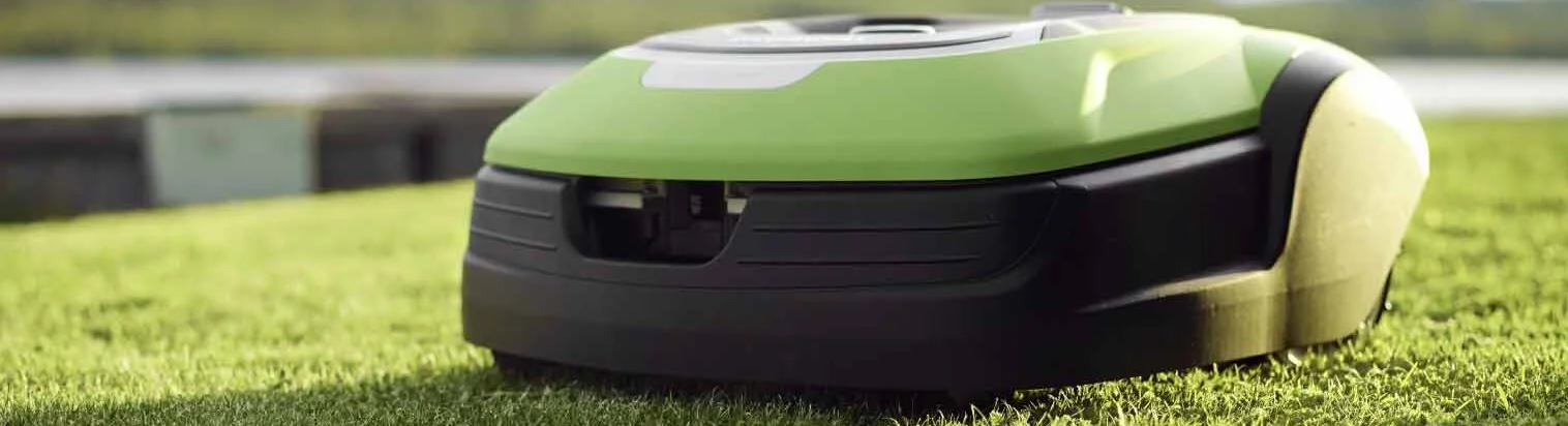 En robotgräsklippare i gräset som fungerar optimalt efter vinterservice